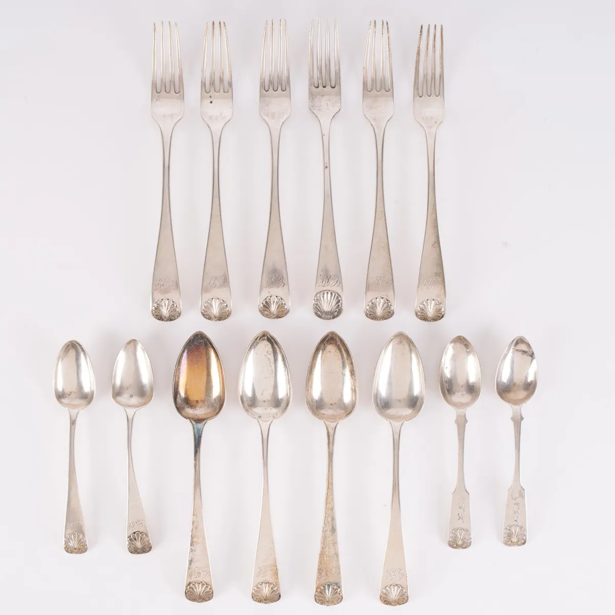 14-piece cutlery set, mainly Russian table silver, handle ends with stylized shell leaf finial.