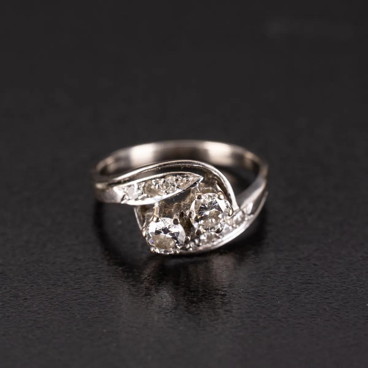 Wunderschöner Brillantring mit 750er Weiß-Goldschiene. Die Ringschultern erweitern sich mittig in 2 Schwüngen, die jewei…