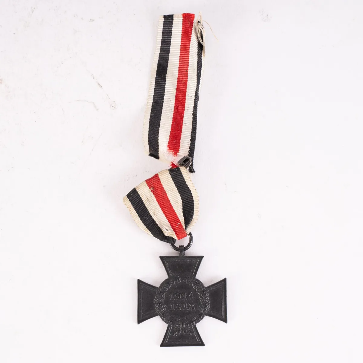 Kříž válečného účastníka 1914-18 na upravené stuze.