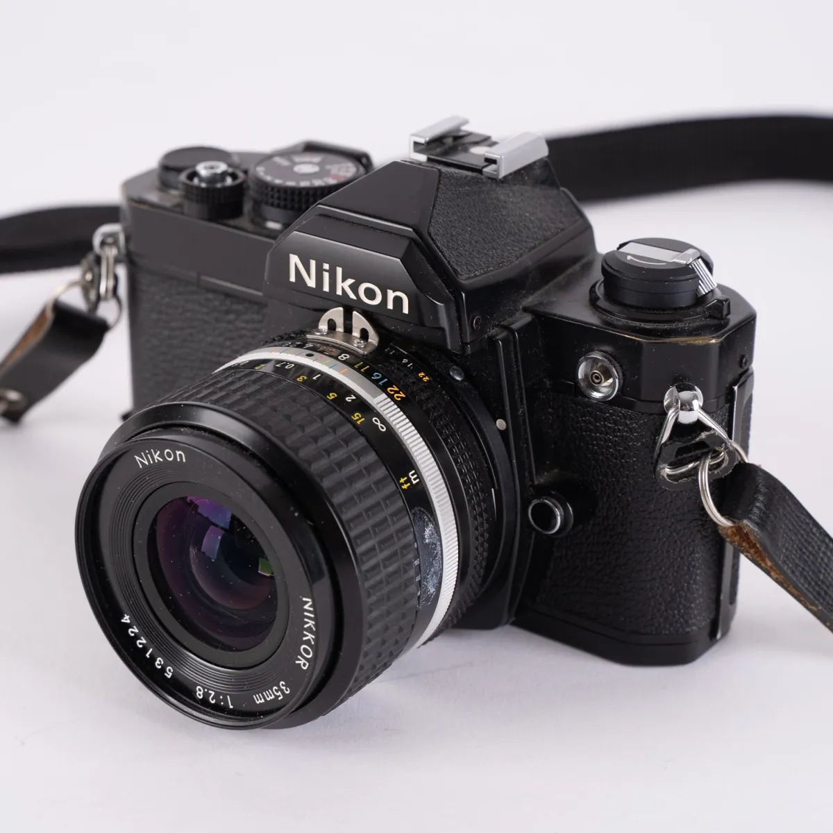 Analog Nikon FM SLR camera, with Nikkor 35 and 85mm lenses, clear optics, untested. In matching aluminum case