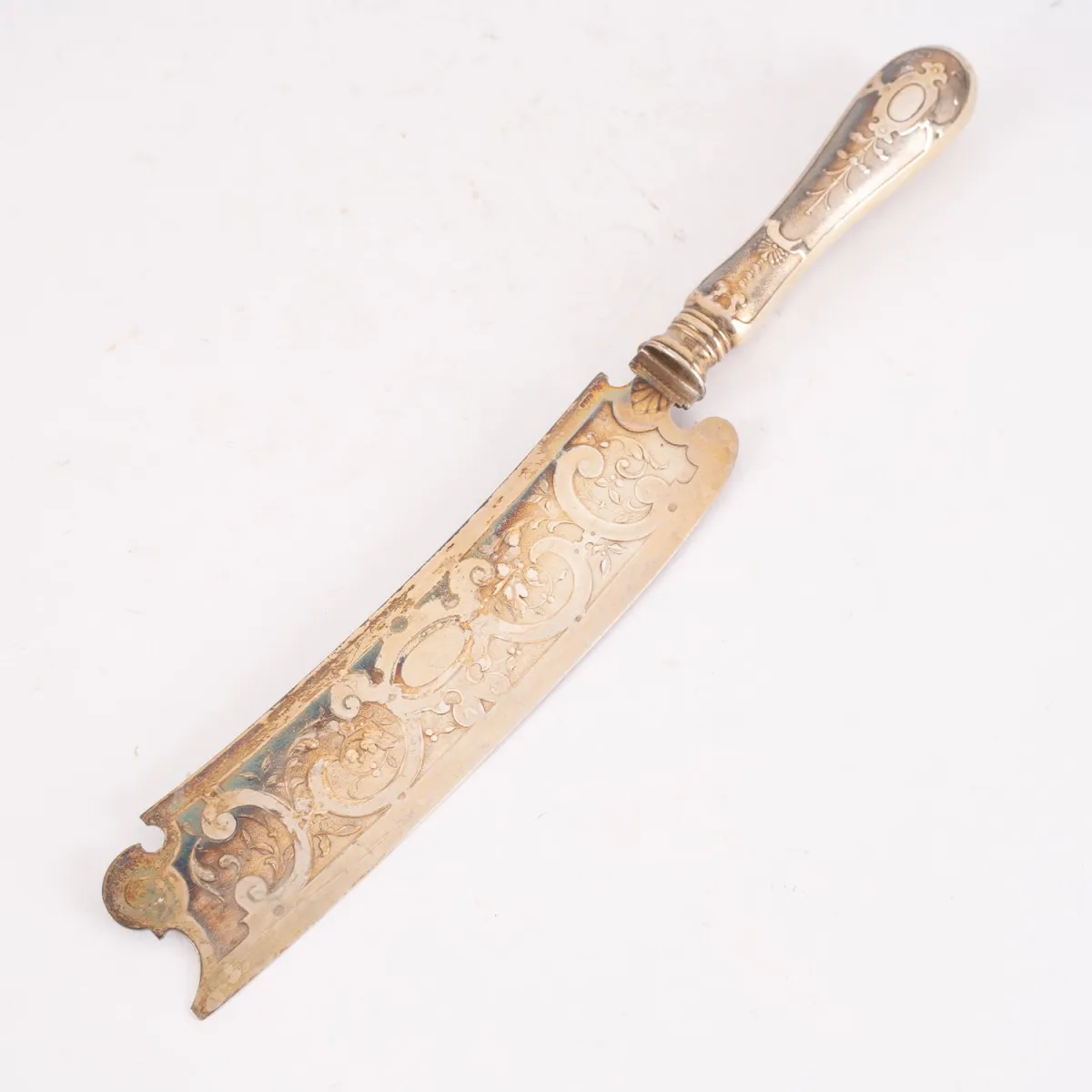 1 Käsemesser, versilbert bzw. vergoldet, reichlich ziseliert auf der Schauseite, Länge ca. 27,5 cm, Breite max. ca. 4 cm…