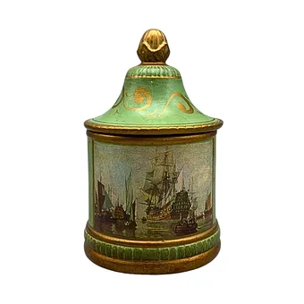 Ceramic lidded box with ship motifs in green.