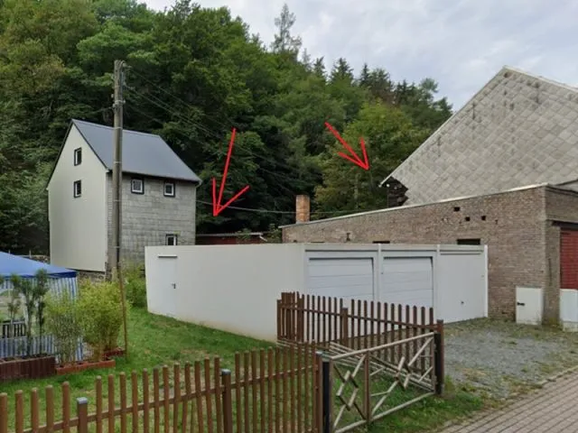 Bewachsene Hoffläche hinter Garagen- und Nebengebäuden
