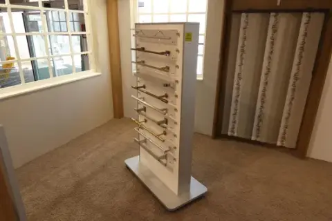 Display stand, with contents (curtain rod samples)