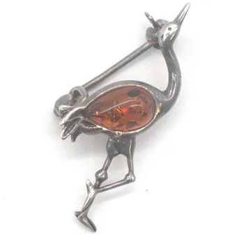 DESIGNER BROSCHE SILBER GEPRÜFT IN PLASTISCHER FORM EINES VOGELS, MIT HONIGBERNSTEIN-CABOCHON BESETZT, DEUTSCHLAND, 20. JAHRHUNDERT, PUNZIERT.