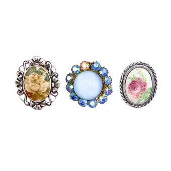 SIERADENLOT VAN DRIE STOFCLIPS MET ROZENMOTIEVEN EN STRASS.