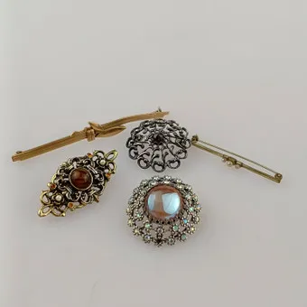 LOT 5 BROCHES, bijoux fantaisie, 20e s., modèles variés en métal argenté et doré