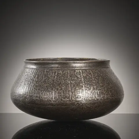 Coupe bombée en fer (?) avec bandeaux d'inscription, figures abstraites et représentations humaines