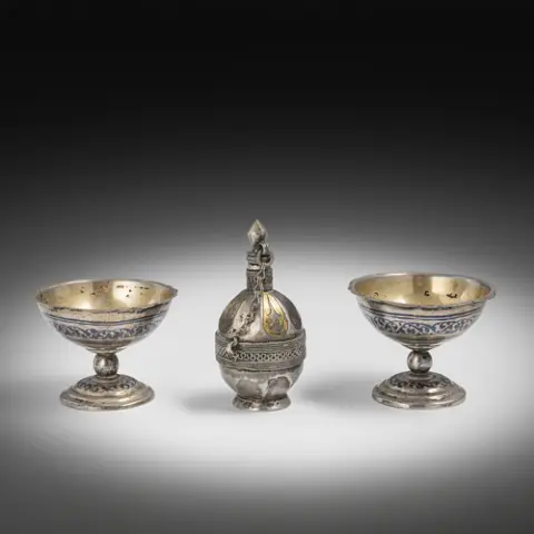 Flacon de parfum et paire de coupes en argent à pied, partiellement décor niellé