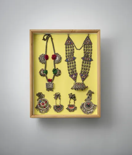 Groupe de bijoux, dont colliers et boucles d'oreilles, partiellement en argent, montés dans deux vitrines