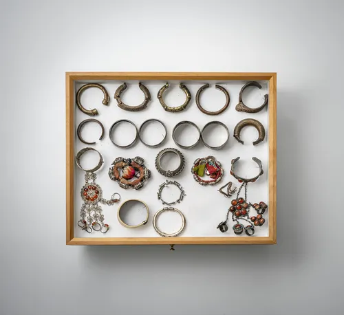 Lot de bracelets, chaînes, pendentifs et boîtes à amulettes, en partie en argent, montés dans deux vitrines