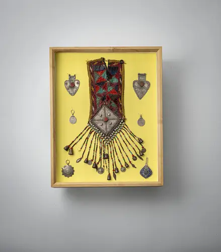 Groep sieraden en hangers, deels zilver, deels verguld, deels met kettinghangers, gemonteerd in twee vitrines