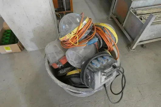 Mörtelkübel mit Baustromverteiler, Bauleuchten und Verlängerungskabeln