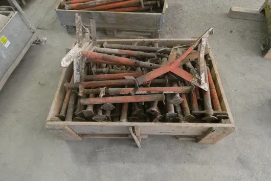 Holzkiste mit Gerüstspindeln und Gerüstbauteilen