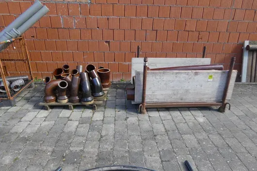 Stapelrek en pallet met gresbuizen en hulpstukken