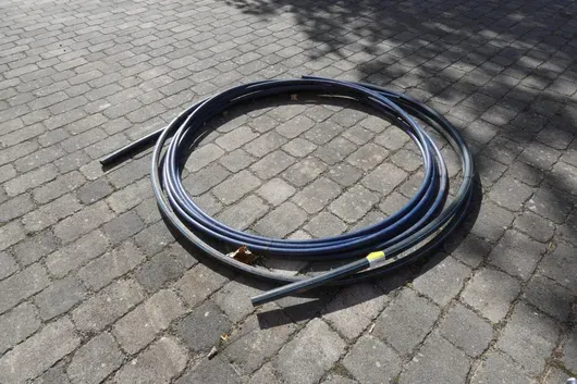 Ring of black PE pipe with blue stripes