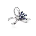 White gold brooch in bow shape with diamonds and sapphires.