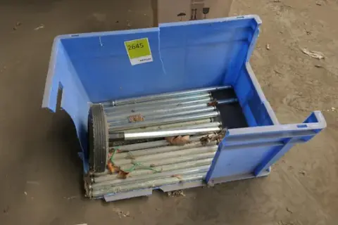 Zestaw wyposażenia magazynowego i eksploatacyjnego m.in. rolki metalowe i koło z osią, w plastikowym pudełku, niebieski