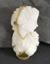 Pendant – carved opal as female portrait in high relief, 585 gold setting, approx. 18.4 g total, with green colored stone, L approx. 5 cm