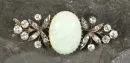 Brosche – 585 GG, ca. 5,0 g total, ovaler Opal, flankiert von silisiertem Blütendekor mit Diamantbesatz, L= ca. 3,8 cm, um 1900;
