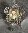 Brosche – 750 GG/Silber, ca. 7,2 g total, durchbrochen gearbeiteter Rahmen im Barockstil, mit Smaragdanhänger, Portraitminiatur,…