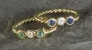 Damesringen, 2 stuks – 750 geelgoud, ca. 3,5 g totaal, getordeerde ringband, met diamanten, saffier en smaragd, maat 47