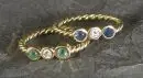 Damesringen, 2 stuks – 750 geelgoud, ca. 3,5 g totaal, getordeerde ringband, met diamanten, saffier en smaragd, maat 47
