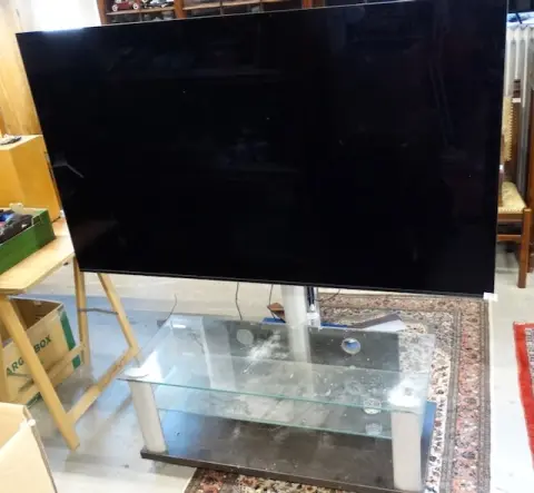 1 grand téléviseur et 1 table de télévision en verre