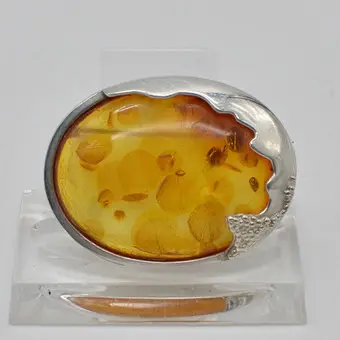 Designer brooch with amber cabochon, leaf inclusions, handmade sterling silver setting, 20th century.