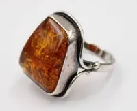 Sølvring med en cognacfarget, trapesformet rav i en glatt 925 sterling sølvfatning.