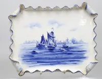 代尔夫特风格陶瓷或瓷质托盘，手绘蓝白海景与帆船图案，卷曲洛可可式边沿。