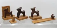 一套手工雕刻的木制梗犬风格摆件和家居饰品（中世纪民间艺术/装饰艺术），包括书立、小笔筒或烛台、托盘和小狗摆件
