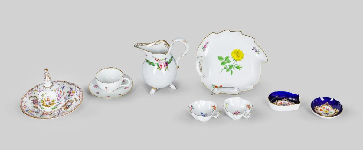 迈森（第一时期）：带托盘桌铃，19世纪，Watteau绘画，金边，直径15.5厘米，高11厘米；摩卡杯，点期，描金玫瑰装饰，金边磨损，托盘后配；奶壶（第二时期），19世纪，装饰饰带和花束，高18厘米，金磨损，修复；叶形碗（第二时期），野花，长19厘米；两个小叶形碗，散花，长8.5厘米；烟灰缸和糖果碗，金底留白配花束