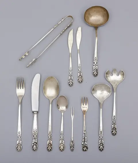 Ménagère, argent 800, décor de roses en relief, dont douze couteaux, fourchettes et cuillères de table, cuillères à café et piques à cocktail, ainsi que six…