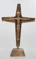 Krucifiks af patineret bronzestøbning med en stiliseret Kristus-figur på en trapezformet fod,