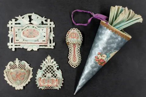 Pap med indsatte og farvet broderede beholdere. Omkring 1900. 8,5 x 8 cm til 10 x 12 cm. Støvet, de indsatte beholdere delvist…