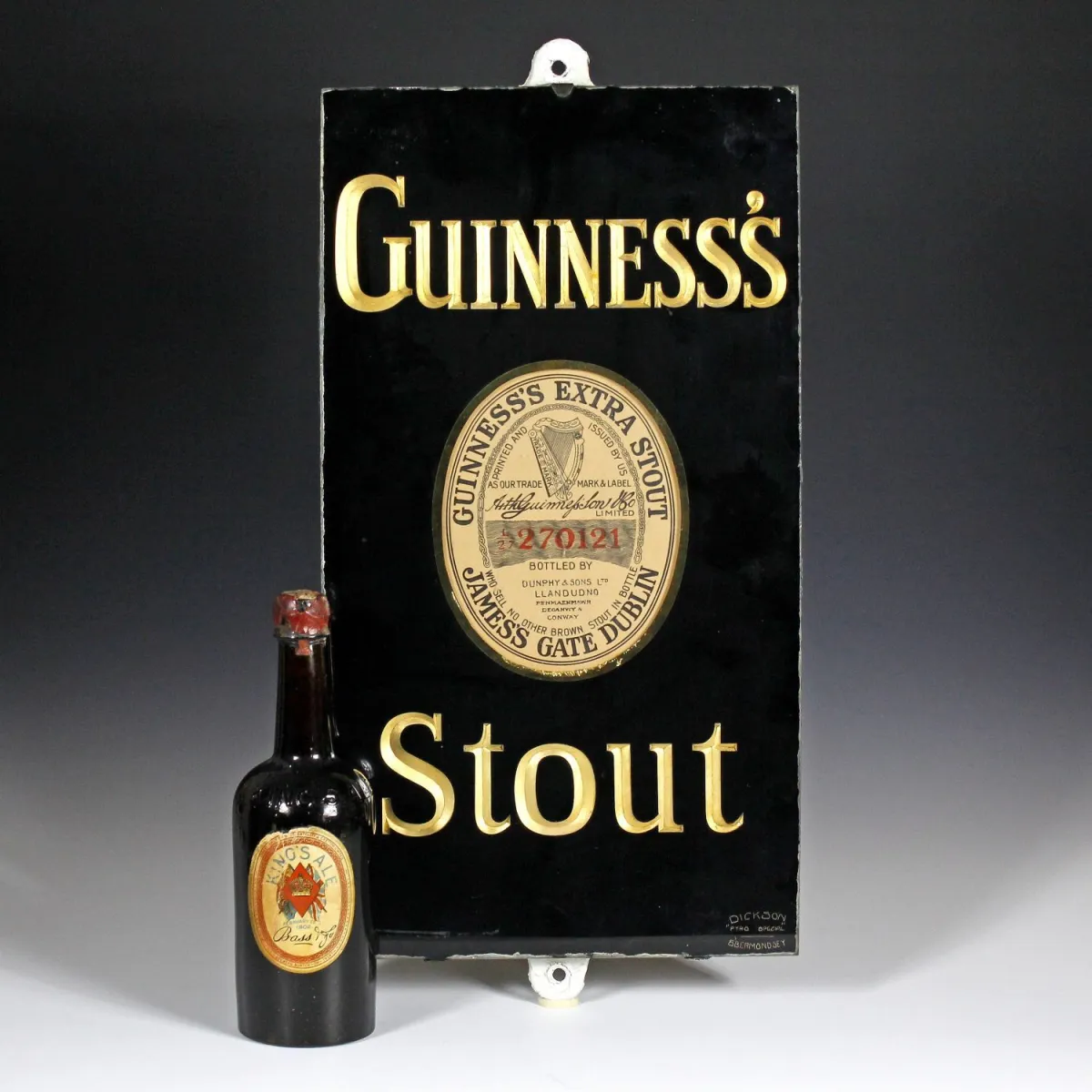 广告 – Guinness's Stout 店铺广告牌。英格兰，约1920年，玻璃背面彩绘，字样浮雕雕刻并镀金，安装在石板上。尺寸：约51 x 28厘米。
