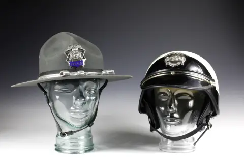 Kuriositeter – To hovedbeklædninger fra det amerikanske politi. Motorcykelhjelm fra California Highway Patrol "Patrolman Police", ca. 1980, politihat "State of Wisconsin Police".
