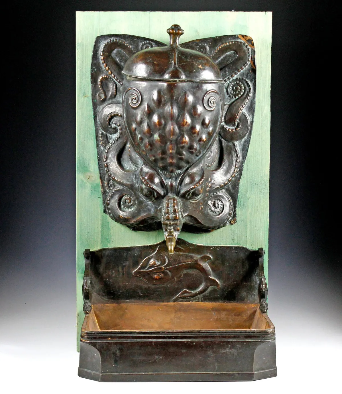 奇珍异品 – 洗手盆。德国，约1920年，新艺术风格壁泉，呈章鱼形状，两侧为一条鳐鱼和两只海马，金属铸造和锻打，安装在木板上。尺寸：约70 x 40 x 28厘米。
