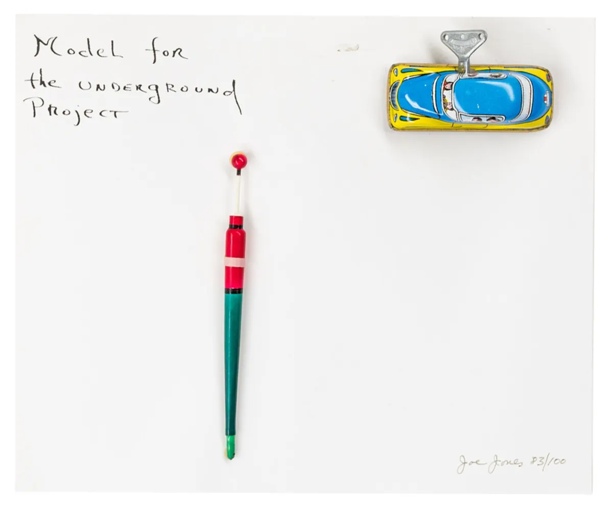 Fluxus – Jones, Joe. Model for the underground project。白色卡纸上的组合艺术品（铁皮车和木浮子）。右下角签名、注明日期并编号，...