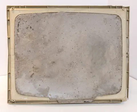 Fluxus – Vostell, Wolf. Endogene Depressionen Nr.9. Betonsculptuur met meegegoten kunststof lijst. 1985. Afmetingen: 35 x 44 x 18 cm.