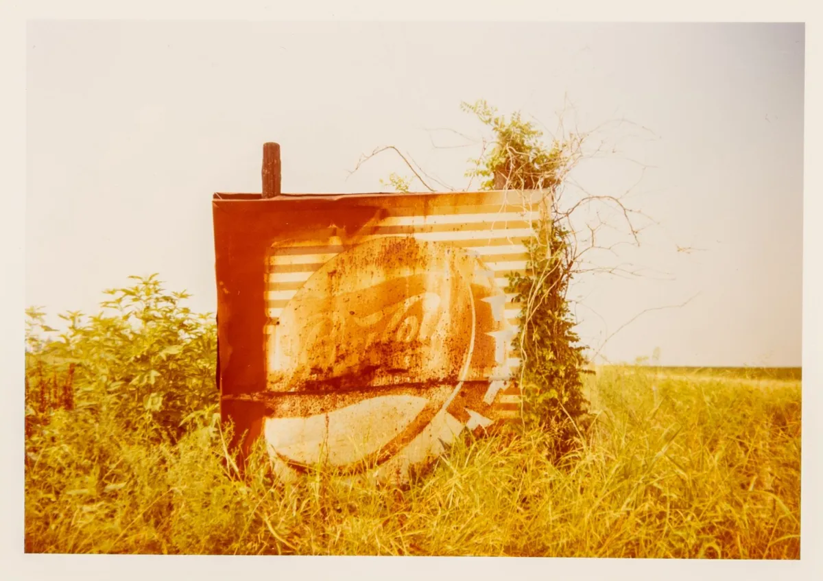 Christenberry, William – 风景中的 Pepsi Cola 招牌，阿拉巴马州 Uniontown 附近。C-print 于 Kodak 照片纸。复古。背面签名。1978年。画面尺寸：8,5 x 12,5 cm。纸张尺寸：20,5 x 25,4 cm。