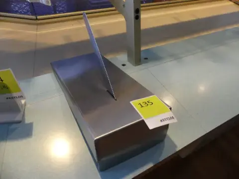 Ruostumattomasta teräksestä valmistettu veitsiteline veitsellä
