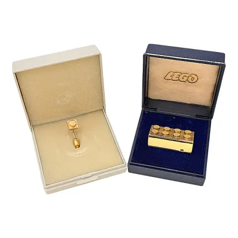 Brique dorée anniversaire Lego et épingle 1x1, or jaune 585, décernées par Lego GmbH, dans des étuis