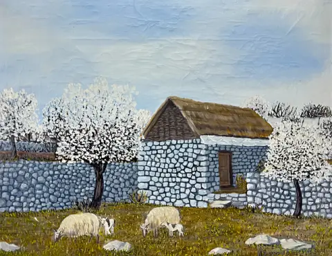 Moutons paissant avec agneaux devant une maison en pierre et un mur, arbres en fleurs au printemps, scène animalière, 1974