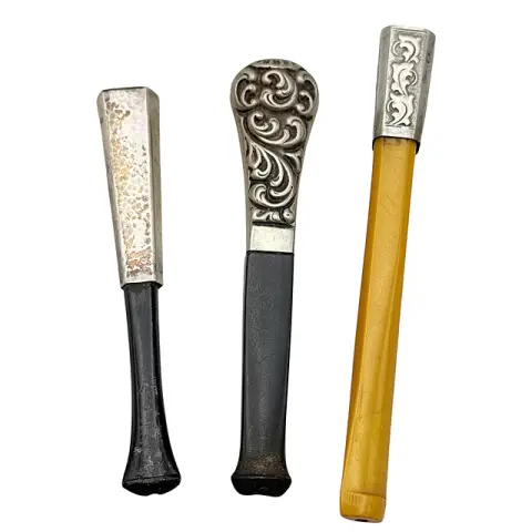 Trois fume-cigarettes, argent 835, relief rocaille et feuillage, embouts en bakélite, Art déco