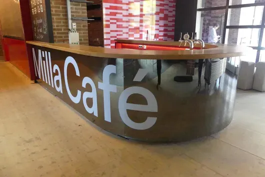 完整吧台设备,带制冷元件、木质台面,正面有“Milla Café”字样