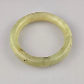 BRACCIALE IN GIADA — Cina, fine tonalità celadon con inclusioni scure isolate.