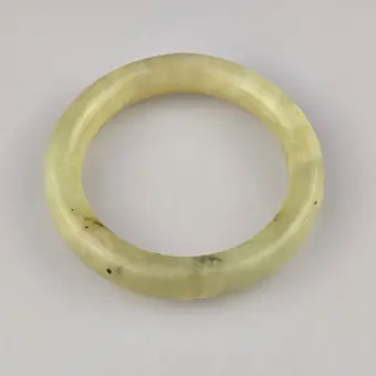 BRACCIALE IN GIADA — Cina, fine tonalità celadon con inclusioni scure isolate.