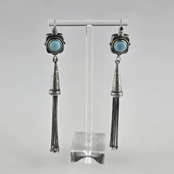 Un paio di orecchini pendenti lunghi in argento con cabochon turchese-blu.
